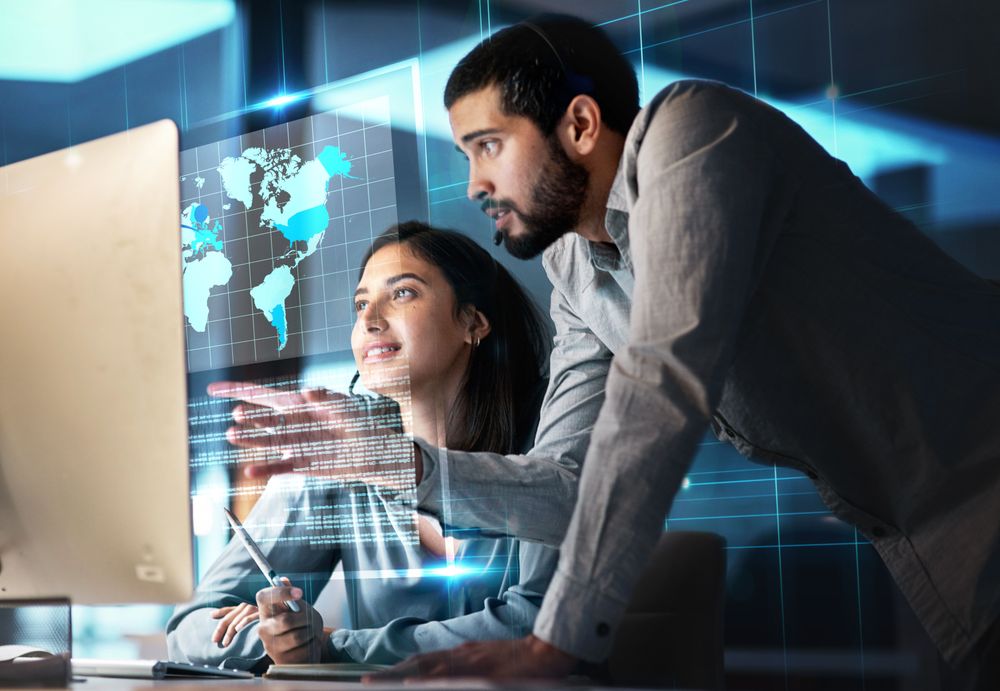 two-colleagues-looking-at-hologram-screen-of-world-map-and-data-getty-1499111154.jpg